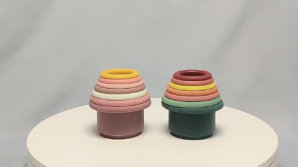 Video zeigt bunte, stapelbare Silikon Spielzeug Becher in verschiedenen Größen. Kinder spielen, stapeln und kombinieren die Becher kreativ, während sie ihre motorischen Fähigkeiten fördern und Spaß haben.